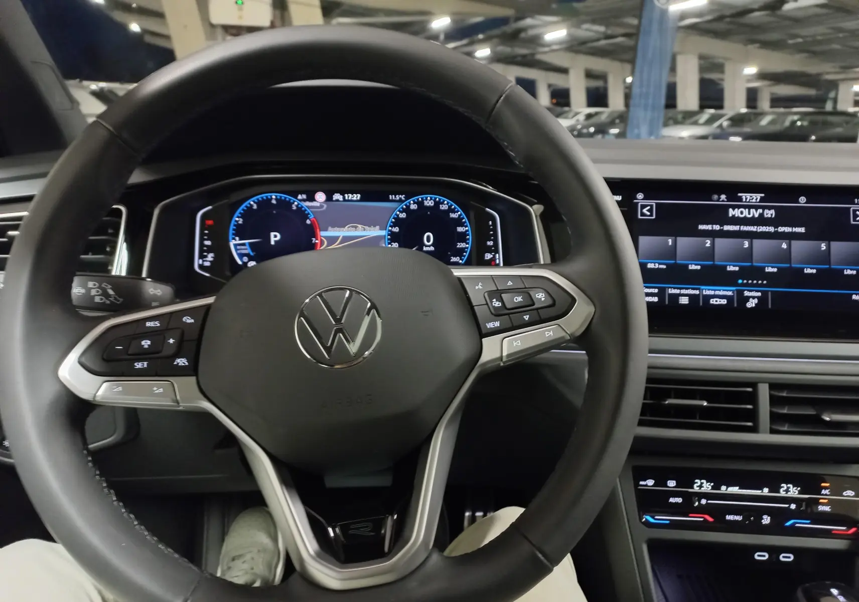 Vue intérieure centrée sur le volant noir du Volkswagen Taigo 2025 avec tableau de bord digital et écran tactile.