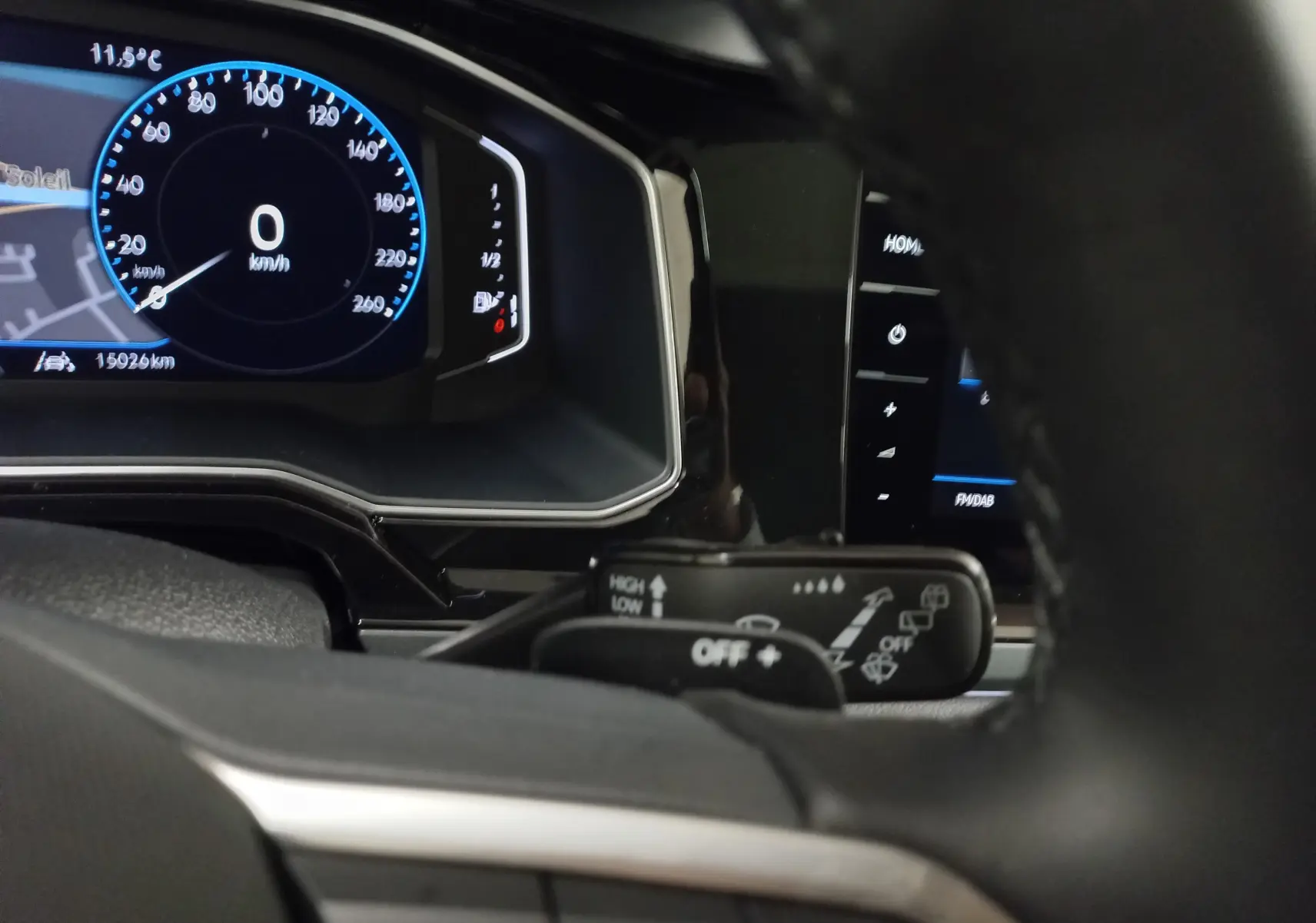 Vue rapprochée du tableau de bord digital du Volkswagen Taigo blanc pur 2025, avec affichage vitesse et commandes au volant.