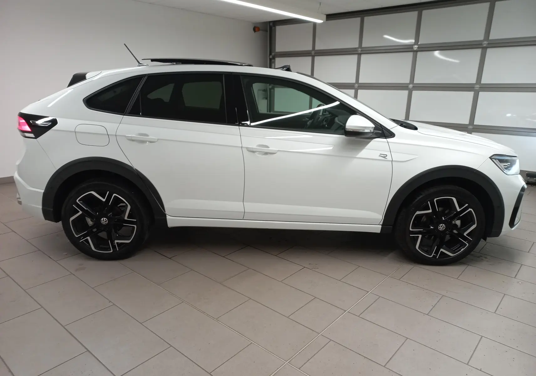 Vue de profil côté gauche du Volkswagen Taigo blanc pur 2025, version R-Line avec jantes noires distinctives.