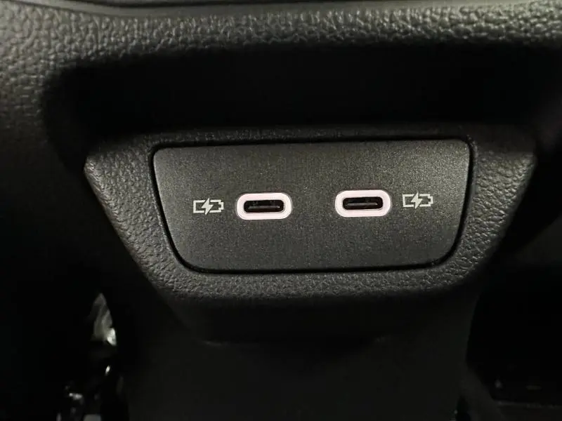 Gros plan sur deux ports USB-C de recharge intégrés dans l'habitacle noir du Volkswagen T-Roc 2025 gris.
