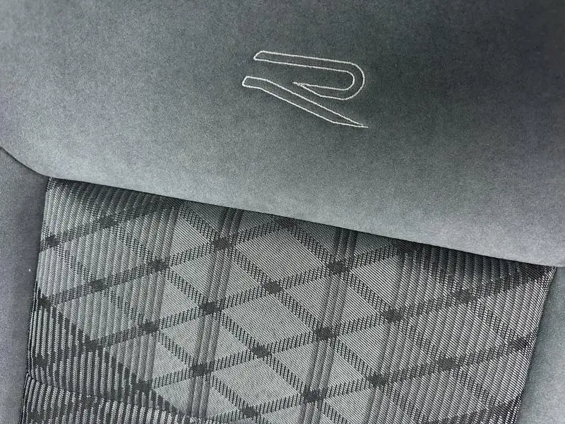Détail de l'assise en artvelours gris silex avec motif géométrique et logo R brodé sur l'appuie-tête du Volkswagen T-Roc.