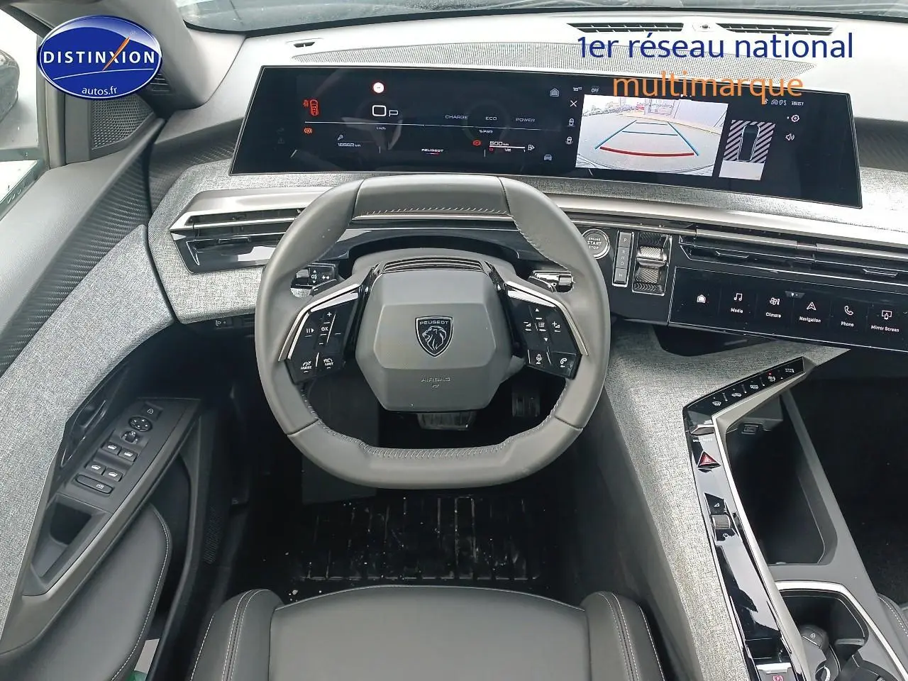 Vue intérieure frontale du tableau de bord gris clair et volant cuir noir du Peugeot 3008 1.2 hybrid 145 allure 2025.