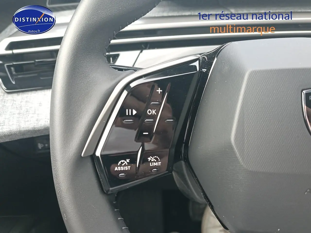 Gros plan sur les commandes multifonctions gauche du volant cuir d’une Peugeot 3008 bleu 2025 hybride.