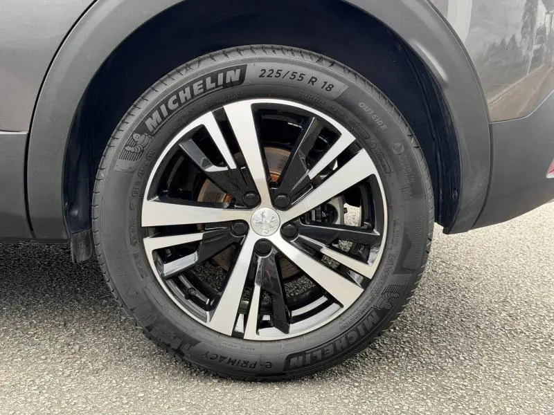 Gros plan sur la roue avant droite du Peugeot 3008 Gris Platinium 2024 avec jante alliage bicolore et pneu Michelin.