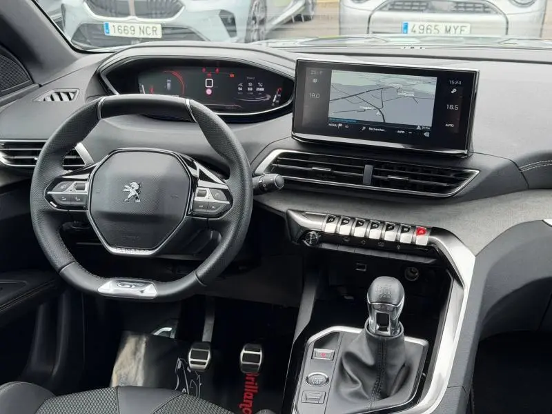 Vue intérieure du tableau de bord du Peugeot 3008 Gris Platinium 2024, avec volant compact, écran tactile et boîte manuelle.