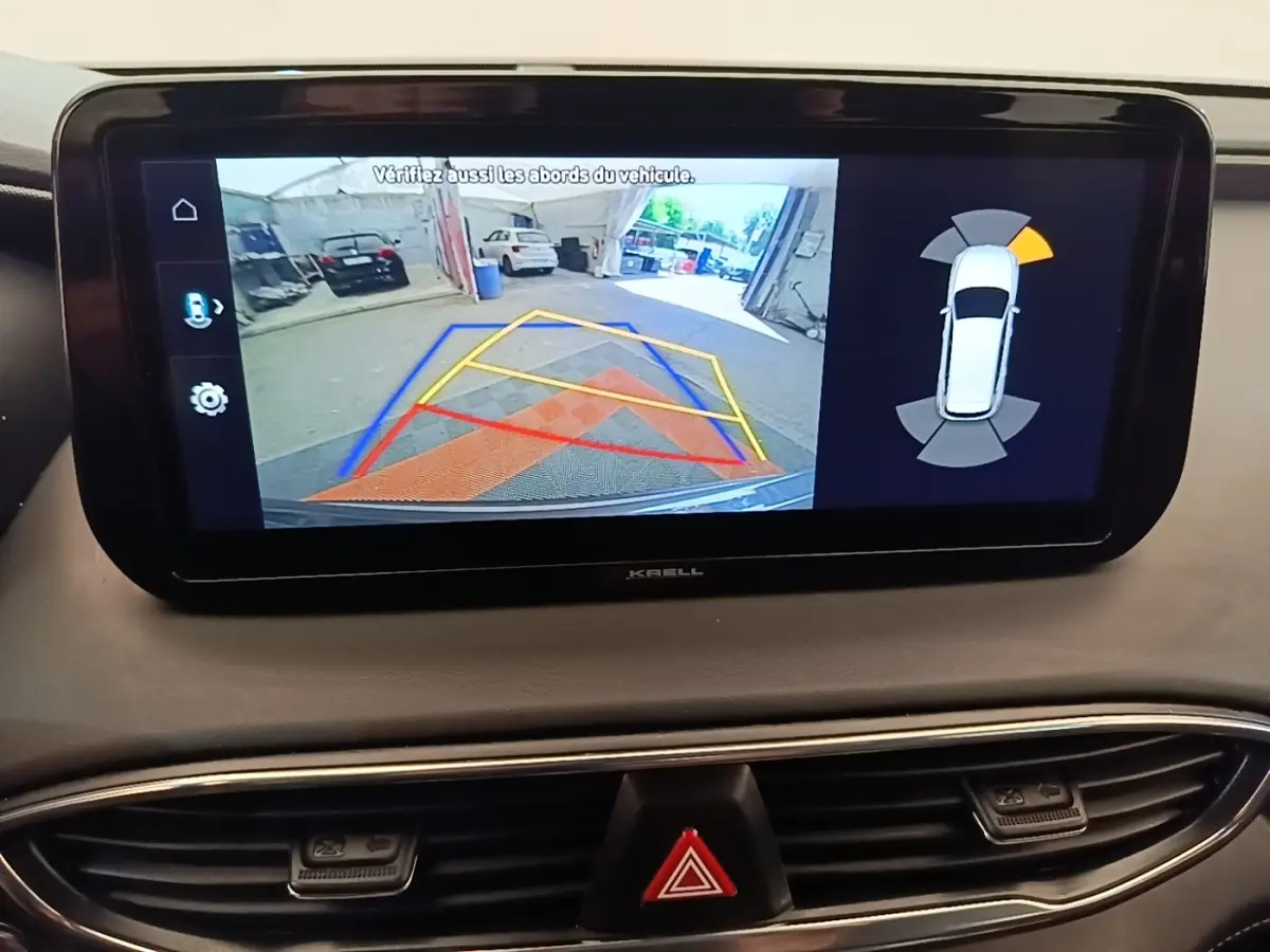 Écran tactile intérieur du Hyundai Santa Fe 2023 montrant la caméra de recul et l’aide au stationnement.