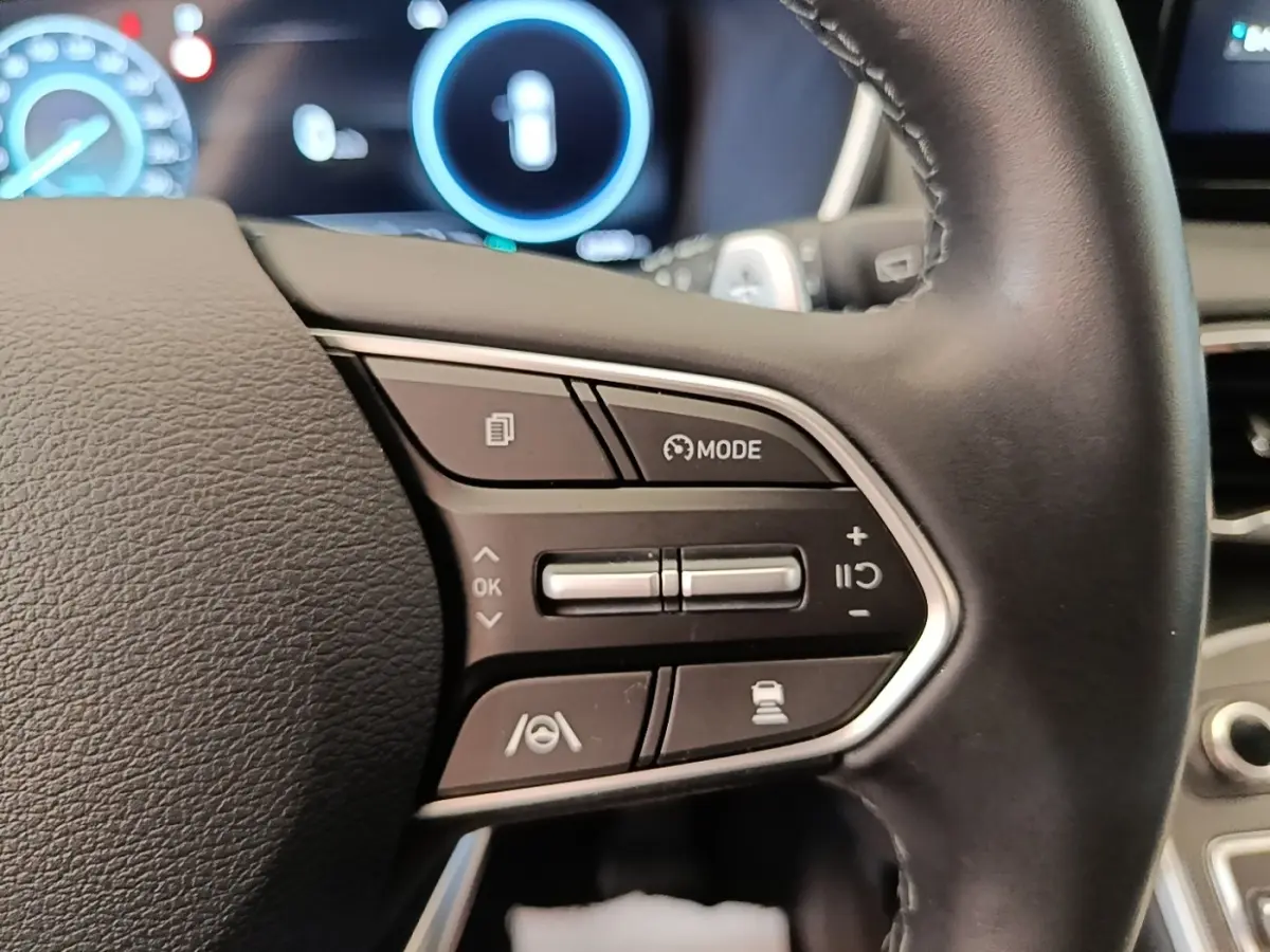 Gros plan sur les commandes multifonctions à droite du volant cuir du Hyundai Santa Fe 2023, affichage numérique en arrière-plan.