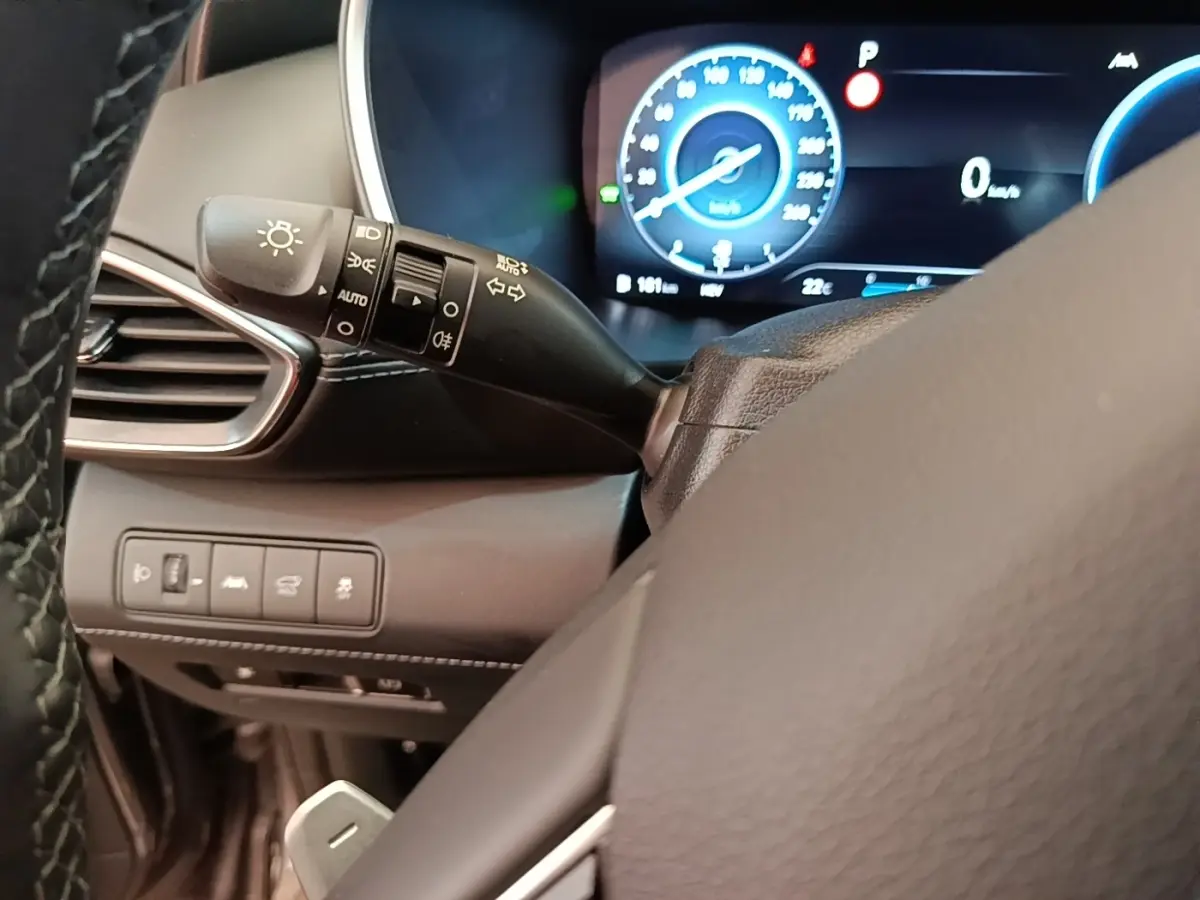 Gros plan sur le commodo gauche et le combiné d'instruments numérique du Hyundai Santa Fe gris foncé 2023.