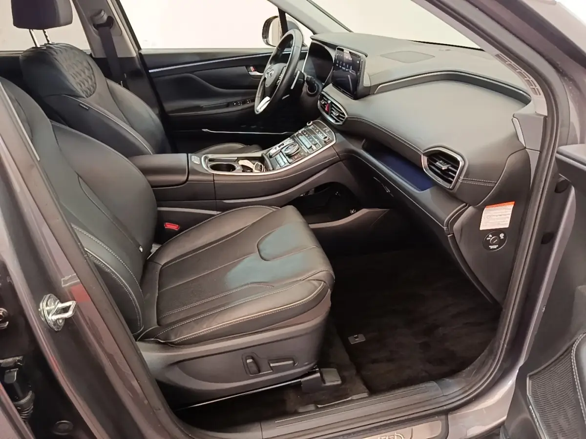 Vue intérieure côté conducteur du Hyundai Santa Fe gris foncé 2023, avec sièges cuir et tableau de bord moderne.