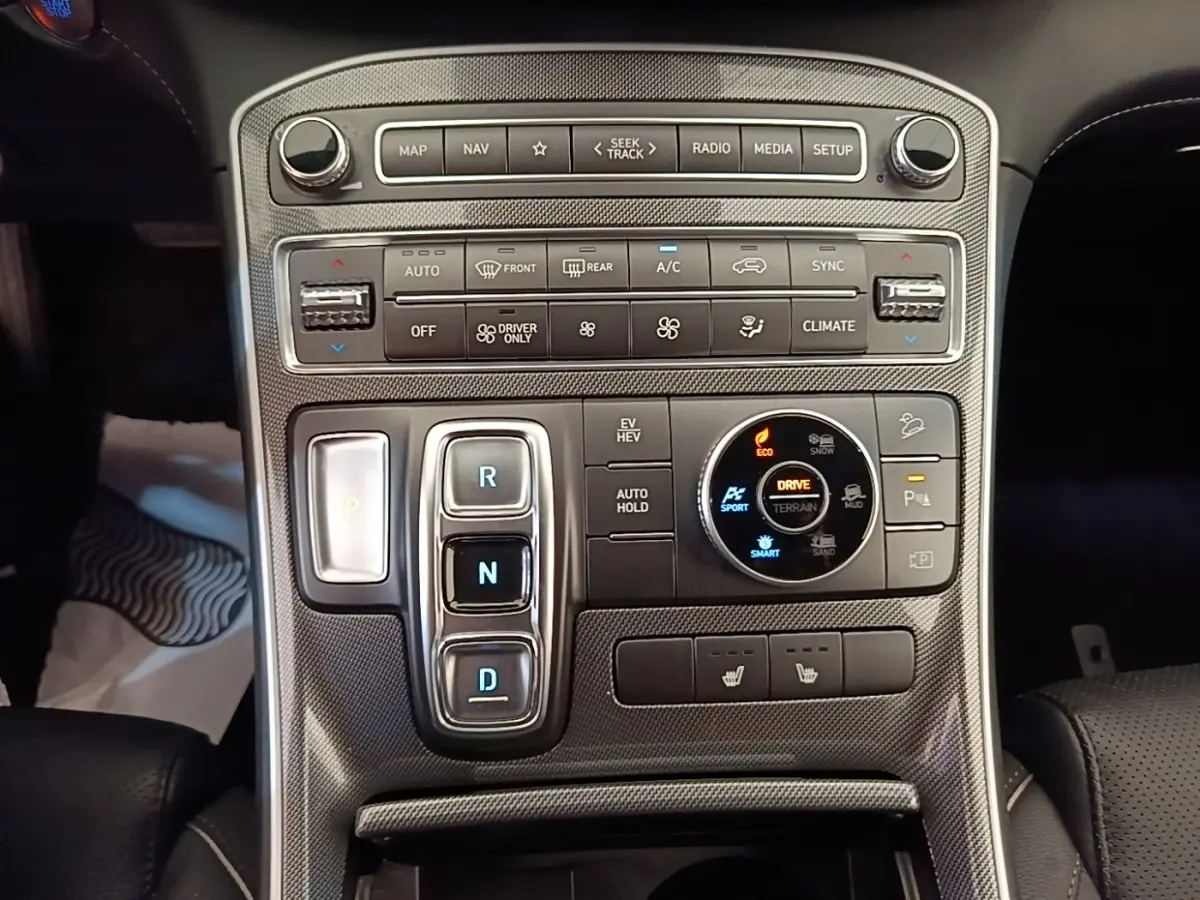 Vue rapprochée de la console centrale du Hyundai Santa Fe 2023, avec commandes de boîte auto et sélection modes terrain.