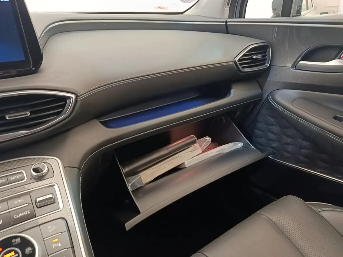 Intérieur côté passager du Hyundai Santa Fe gris foncé 2023, avec boîte à gants ouverte et tableau de bord noir.