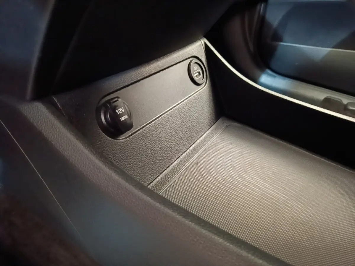 Prise 12V et bouton verrouillage dans le compartiment de rangement intérieur du Hyundai Santa Fe gris foncé.