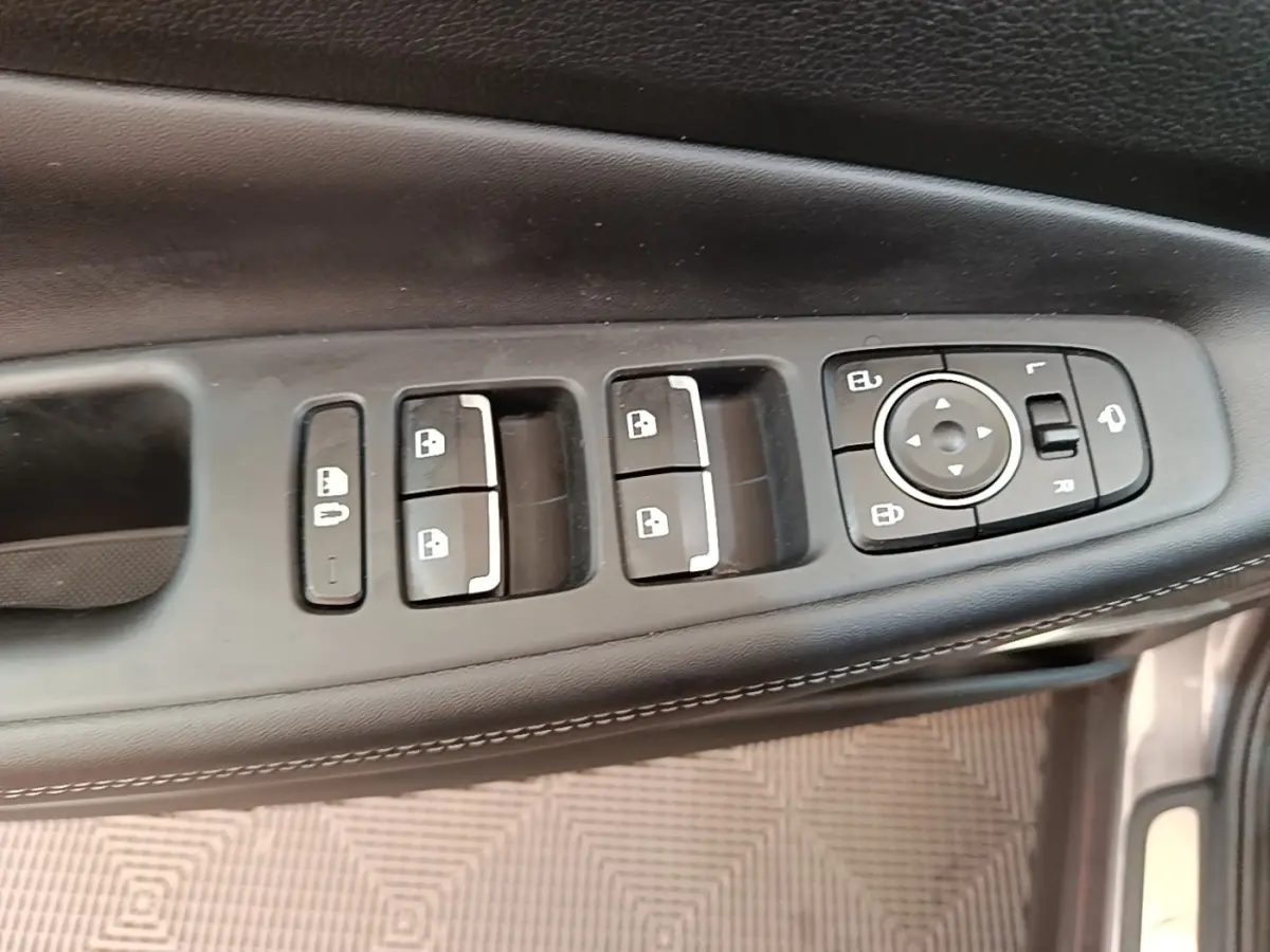Vue rapprochée des commandes de porte côté conducteur du Hyundai Santa Fe gris foncé, avec boutons de verrouillage et réglage des rétroviseurs.