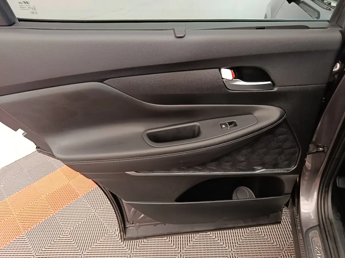 Porte arrière droite ouverte du Hyundai Santa Fe gris foncé, montrant le panneau intérieur noir avec commande de vitre.
