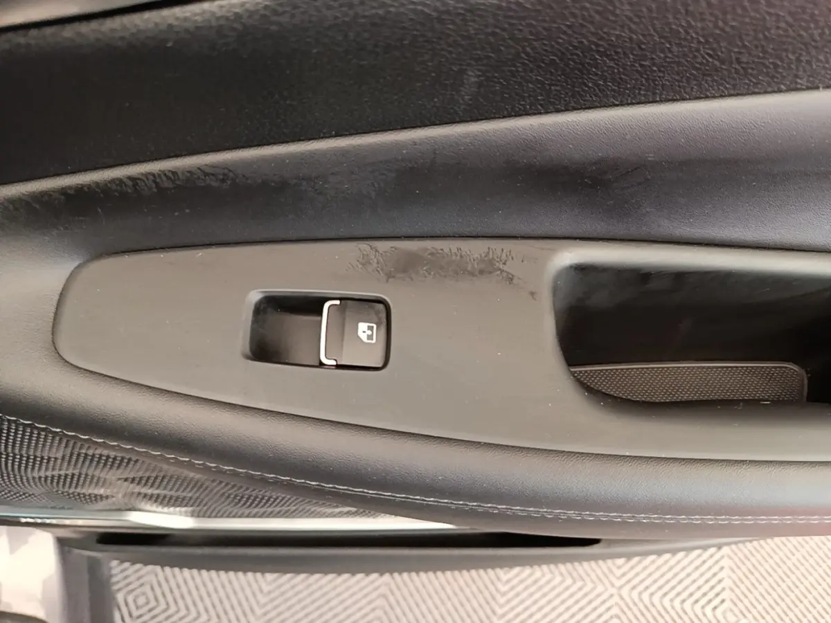 Détail de la poignée intérieure de porte côté gauche du Hyundai Santa Fe gris foncé, avec bouton de verrouillage.