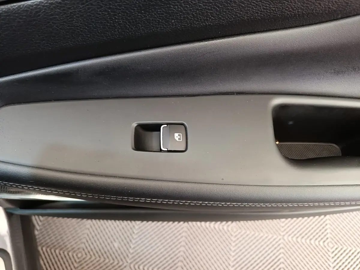 Gros plan sur la commande de verrouillage de porte intérieure noire du Hyundai Santa Fe gris foncé, côté conducteur.