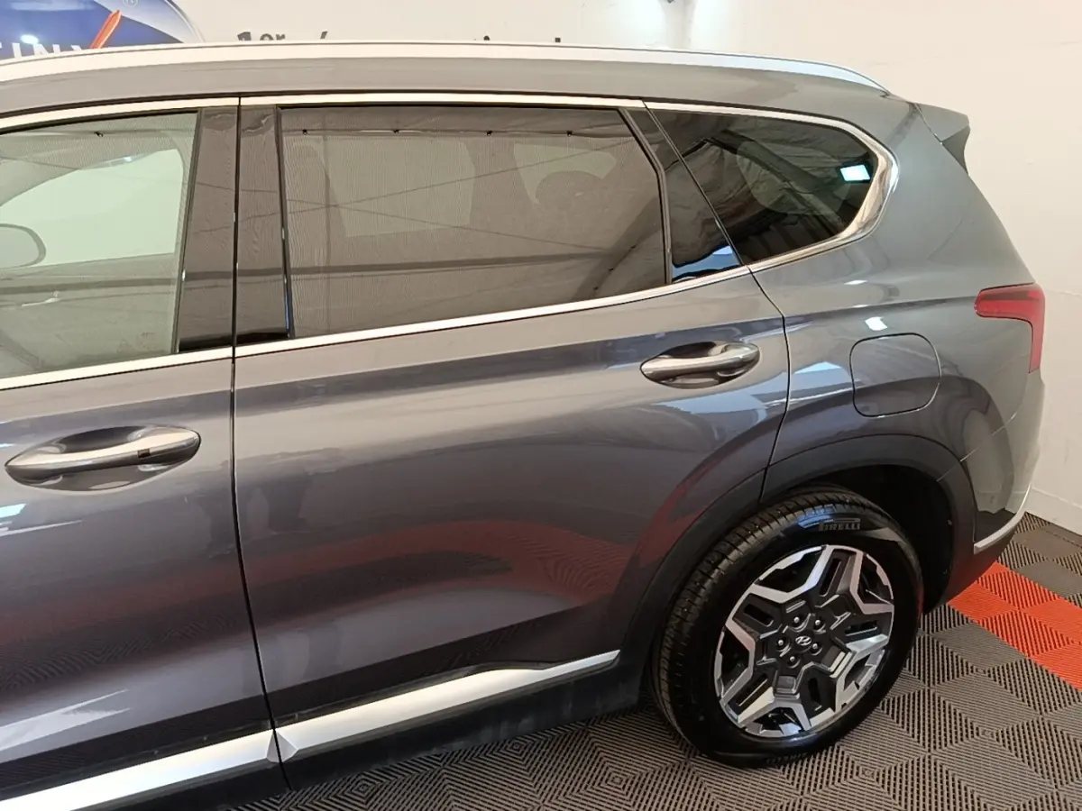 Vue latérale côté droit du Hyundai Santa Fe gris foncé 2023, mettant en valeur la jante alliage et les vitres teintées.