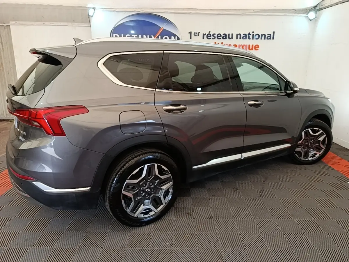 Vue de profil droit du Hyundai Santa Fe gris foncé 2023, avec jantes alliage distinctives et toit chromé.