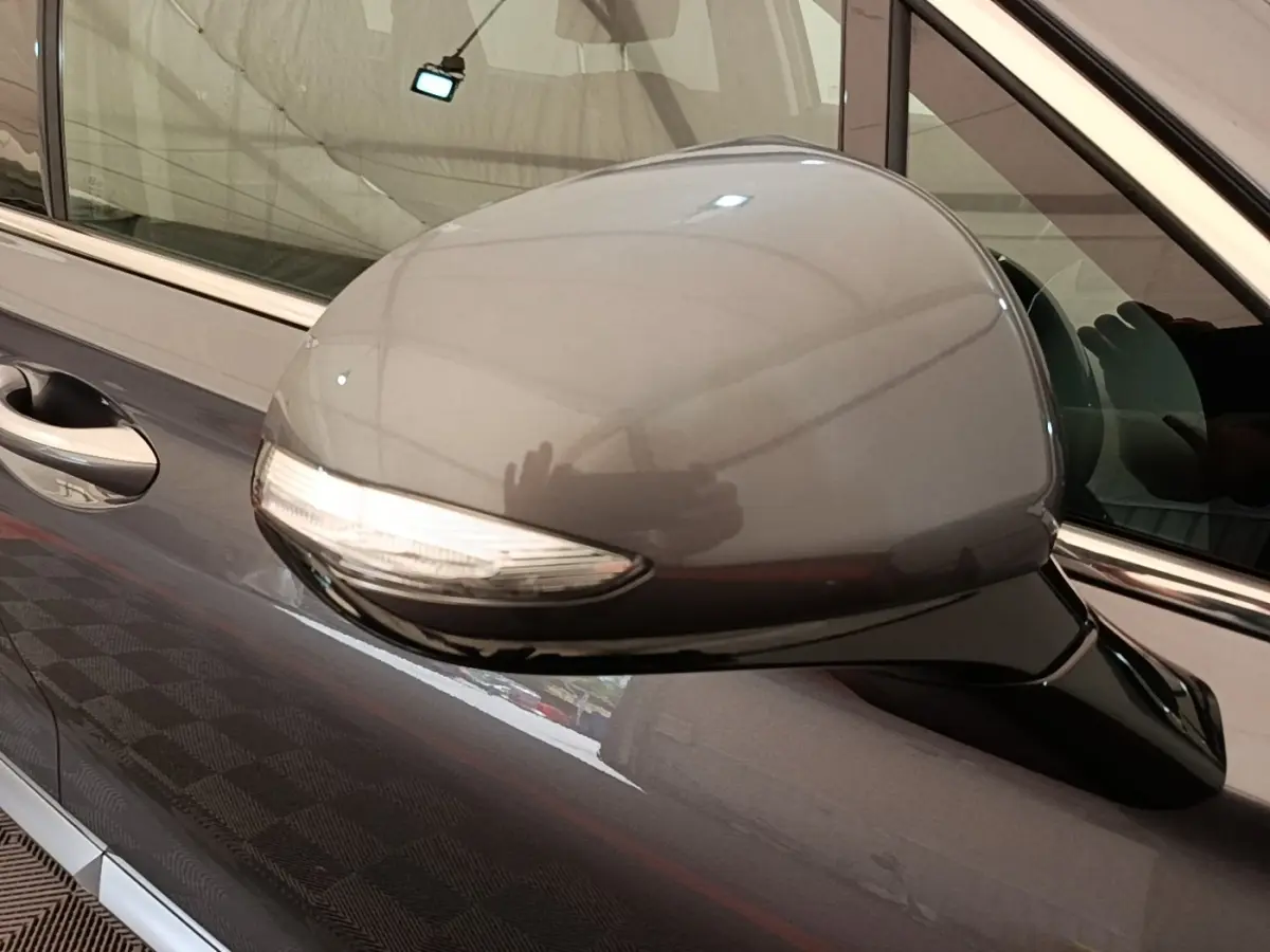 Rétroviseur côté conducteur gris foncé du Hyundai Santa Fe 2023 avec clignotant intégré, vue rapprochée côté gauche.