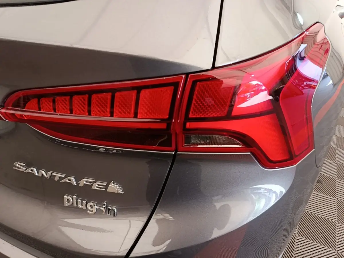 Gros plan sur le feu arrière droit et le logo Santa Fe plug-in d'un Hyundai Santa Fe gris foncé.