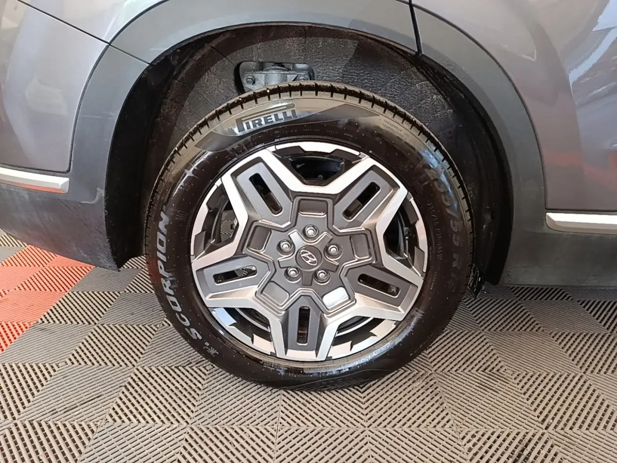 Gros plan sur la roue avant droite gris foncé du Hyundai Santa Fe 2023 avec jante alliage et pneu Pirelli Scorpion.