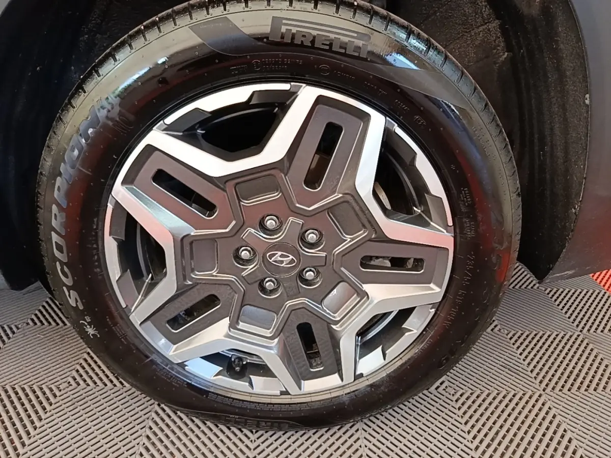 Gros plan sur la roue avant droite du Hyundai Santa Fe gris foncé, jante alliage au design moderne et pneu Pirelli.