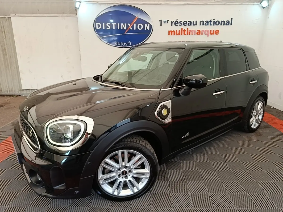 MINI Countryman Cooper SE noir vue 3/4 avant droit, avec jantes argentées et badge hybride rechargeable visible.