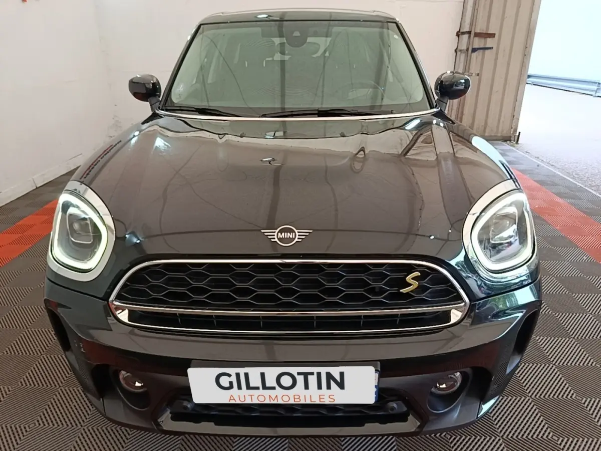 Vue avant d'une MINI Countryman noire avec phares LED allumés et calandre hexagonale distinctive.