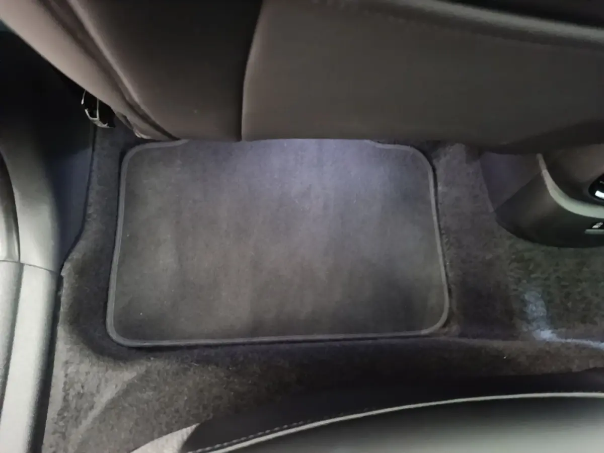 Tapis de sol noir au sol de l'habitacle arrière d'un MINI COUNTRYMAN Cooper SE 2023, vue centrée vers l'avant.