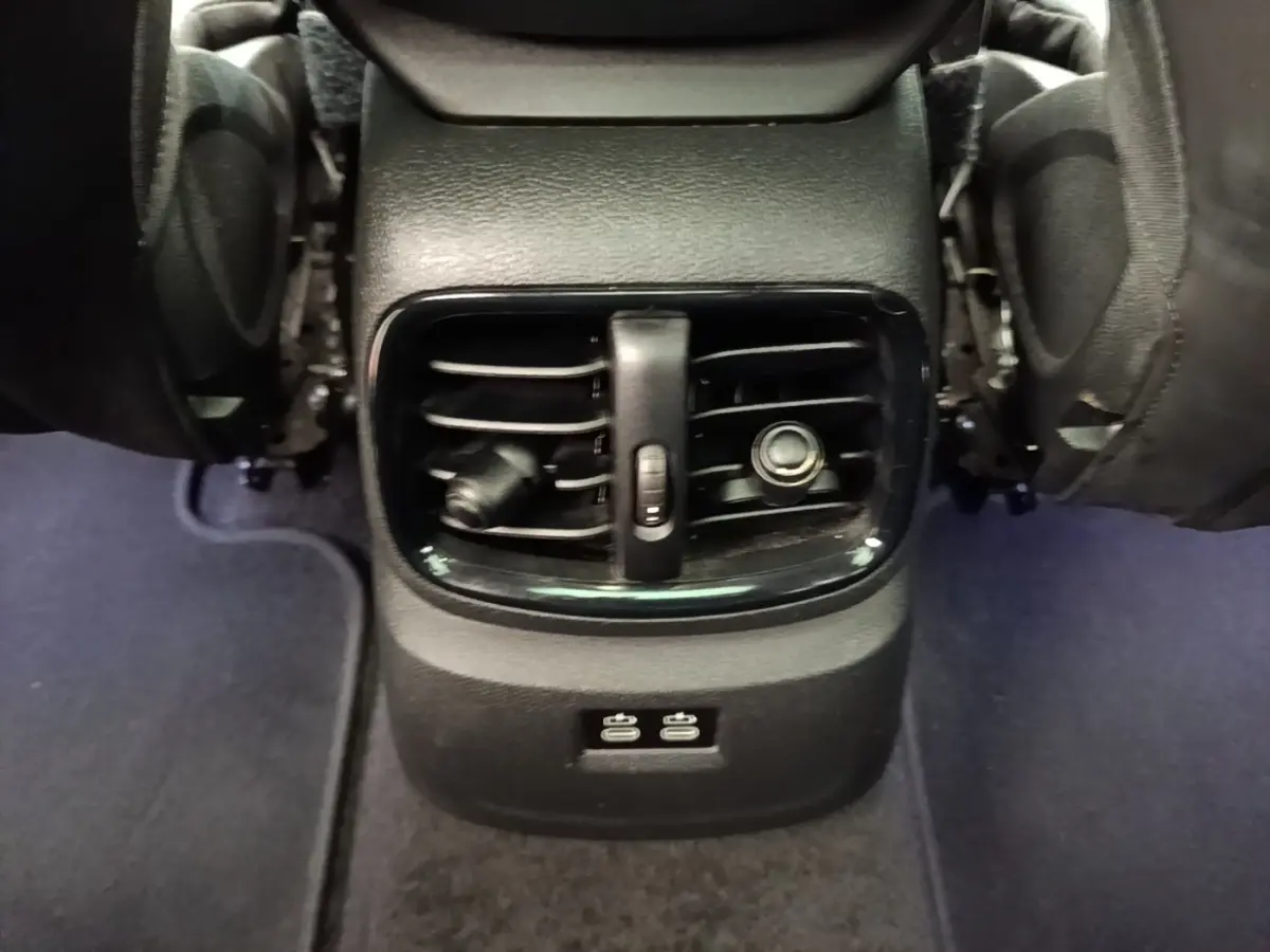 Vue rapprochée des aérateurs arrière noirs et des ports USB du MINI Countryman Cooper SE 2023, entre les sièges.