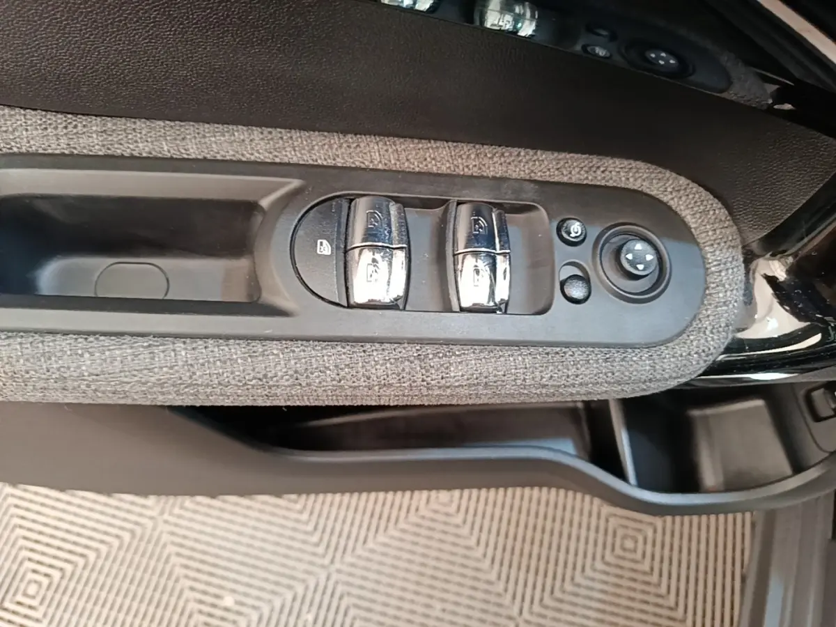 Commande des vitres et réglage des rétroviseurs sur la portière côté conducteur d'une MINI Countryman noire 2023.