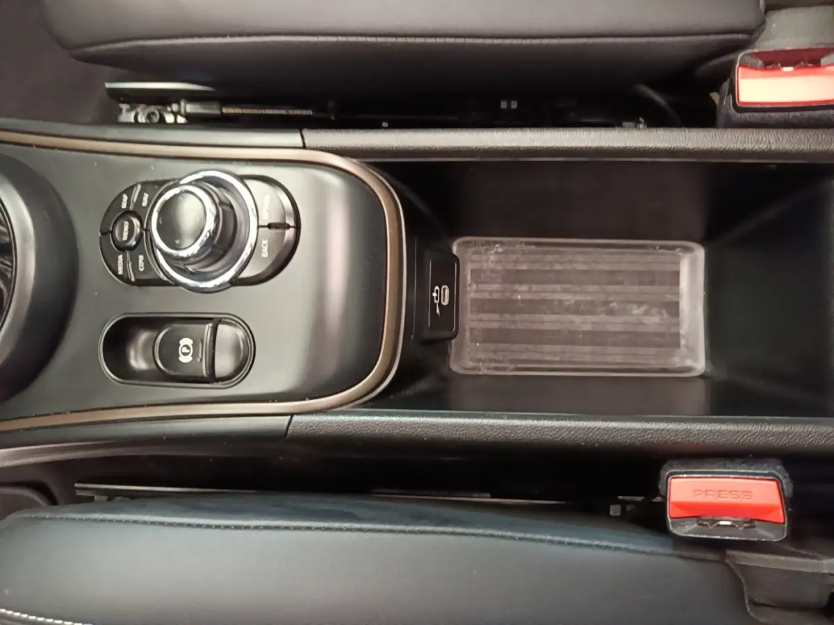 Vue rapprochée de la console centrale noire du MINI COUNTRYMAN 2023 avec commandes et frein à main électrique.