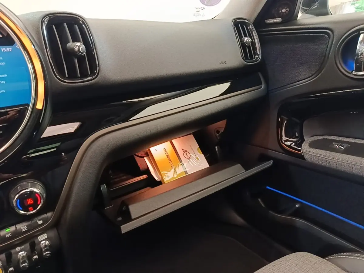 Intérieur côté passager du MINI Countryman noir 2023, boîte à gants ouverte avec notice visible.
