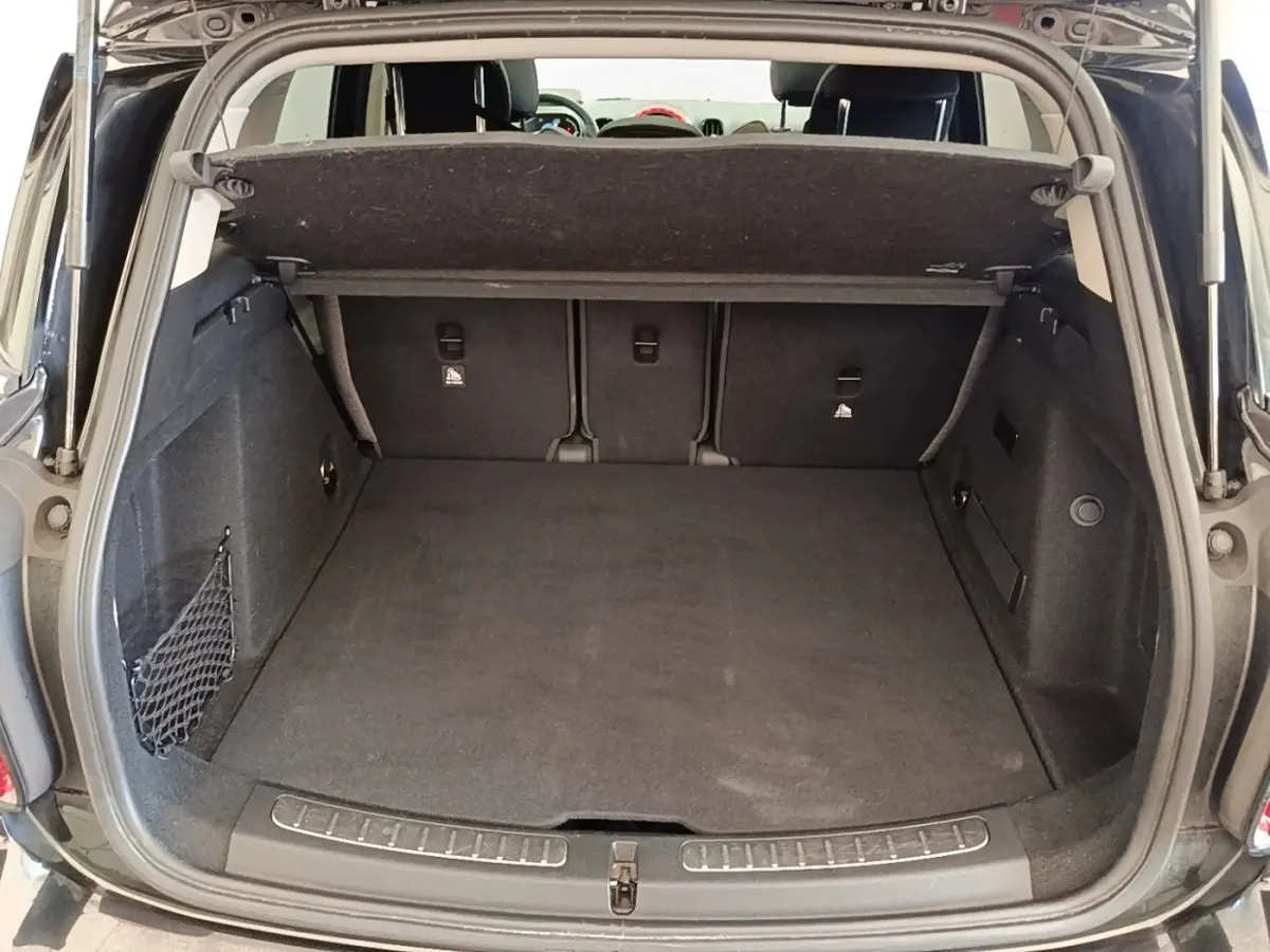 Coffre ouvert noir du MINI COUNTRYMAN Cooper SE 2023, vue arrière montrant l’espace de chargement et la banquette rabattable.