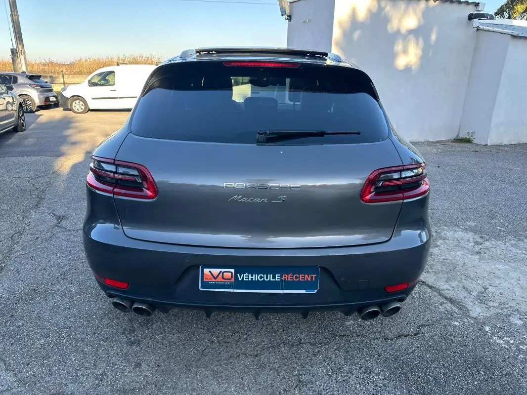 Vue arrière d'un Porsche Macan S gris foncé avec feux LED, double sortie d'échappement et vitre arrière teintée.