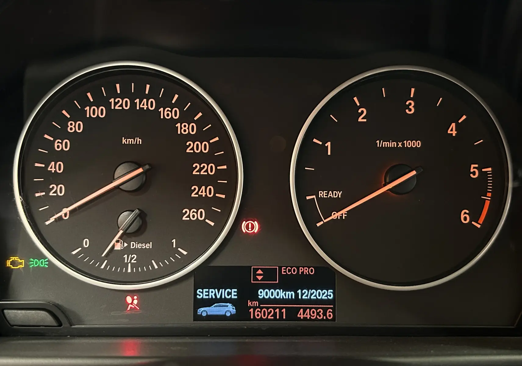 Tableau de bord de BMW Série 1 gris diesel 2014, affichant compte-tours, vitesse et alertes service.