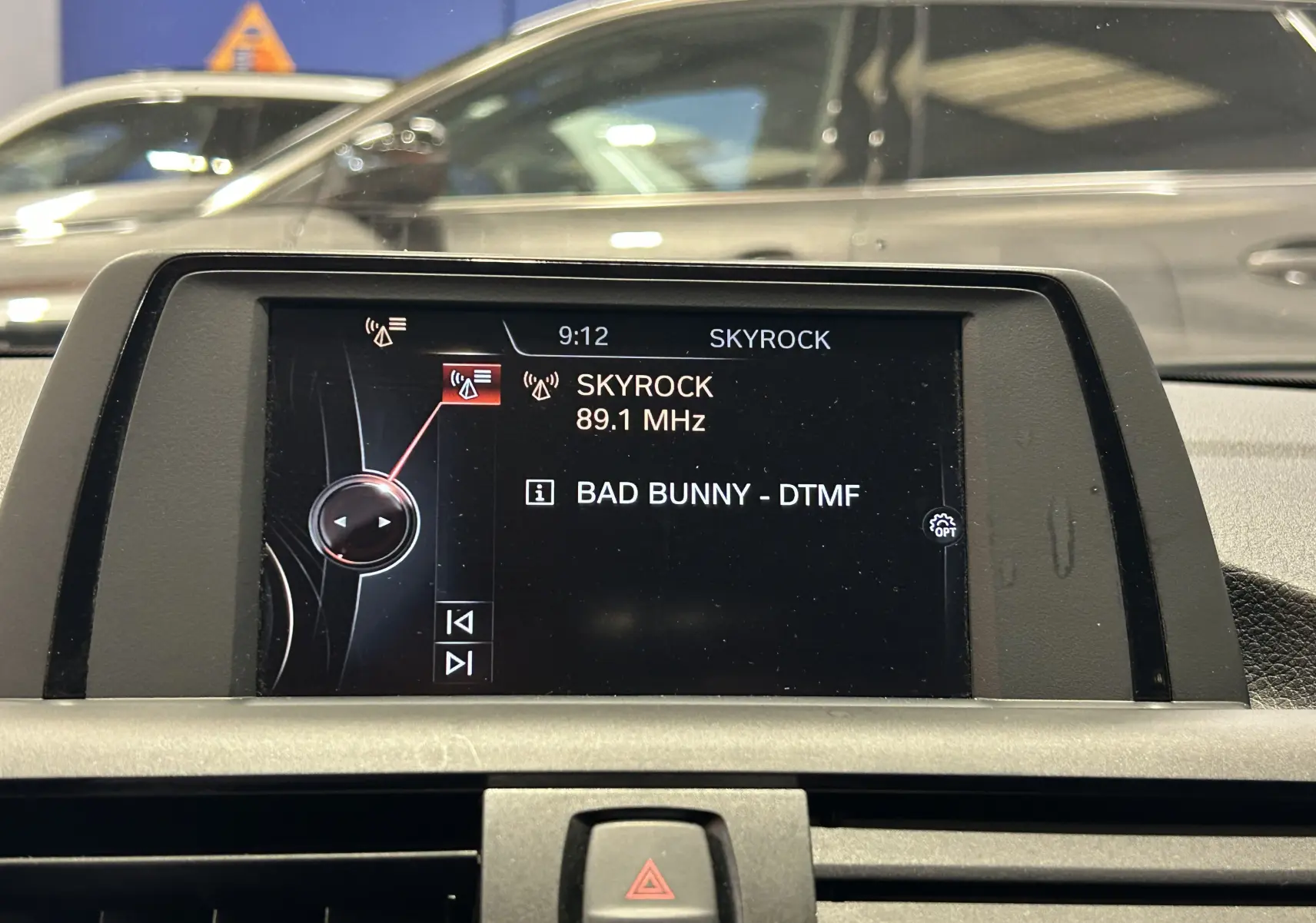Écran central de la BMW Série 1 gris 2014 affichant la radio sur Skyrock à 89.1 MHz, vue intérieure frontale.