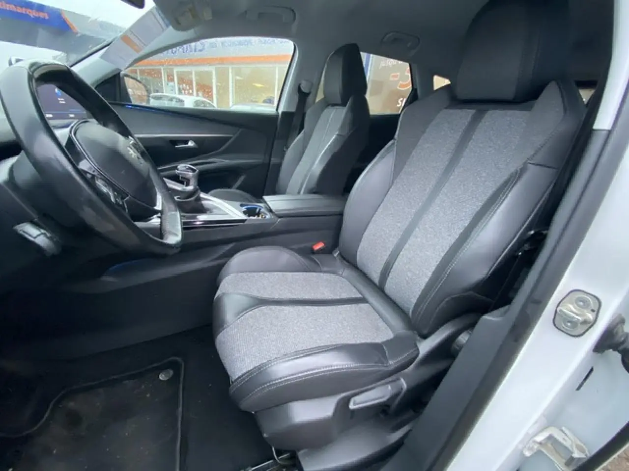 Vue intérieure côté conducteur du Peugeot 3008 blanc 2017 avec sellerie TEP et tissu gris et noir.