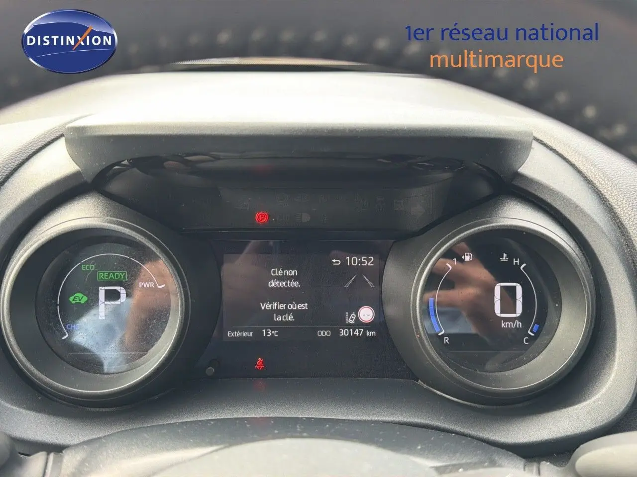 Vue rapprochée du tableau de bord numérique de la Toyota Yaris Cross gris minéral, affichant 30 147 km et indicateurs hybrides.