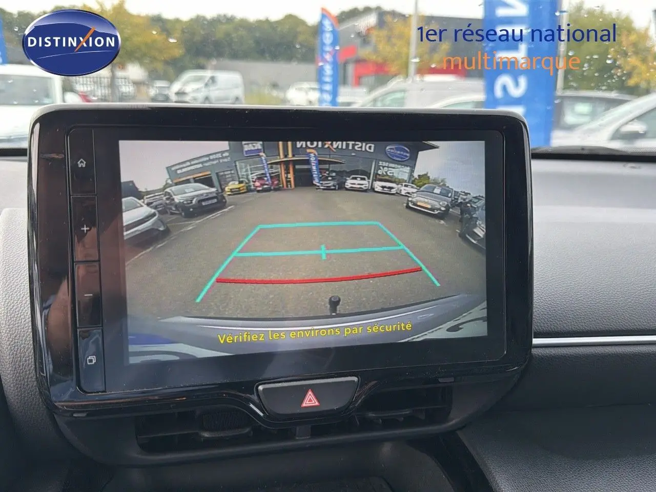 Écran tactile intérieur montrant la caméra de recul d'une Toyota Yaris Cross gris minéral, vue depuis le tableau de bord.