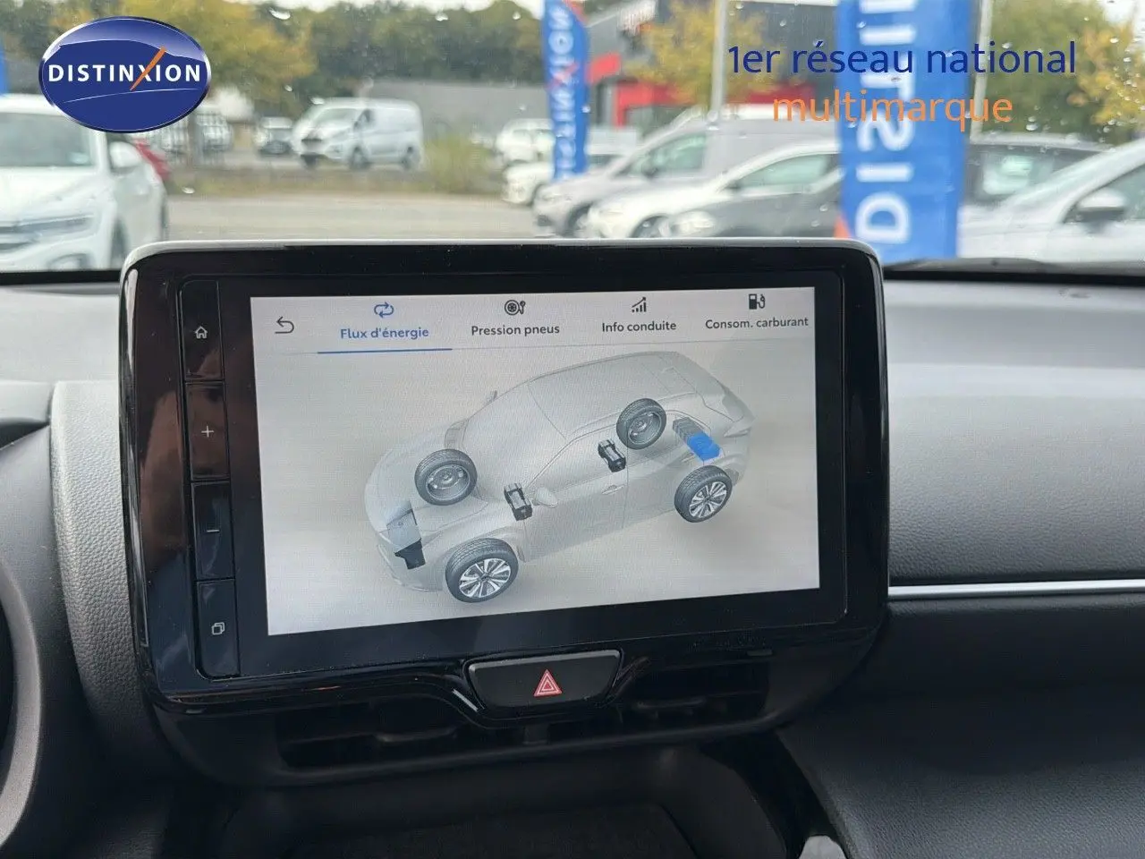 Écran tactile central affichant le flux d'énergie d'une Toyota Yaris Cross hybride, intérieur noir visible.