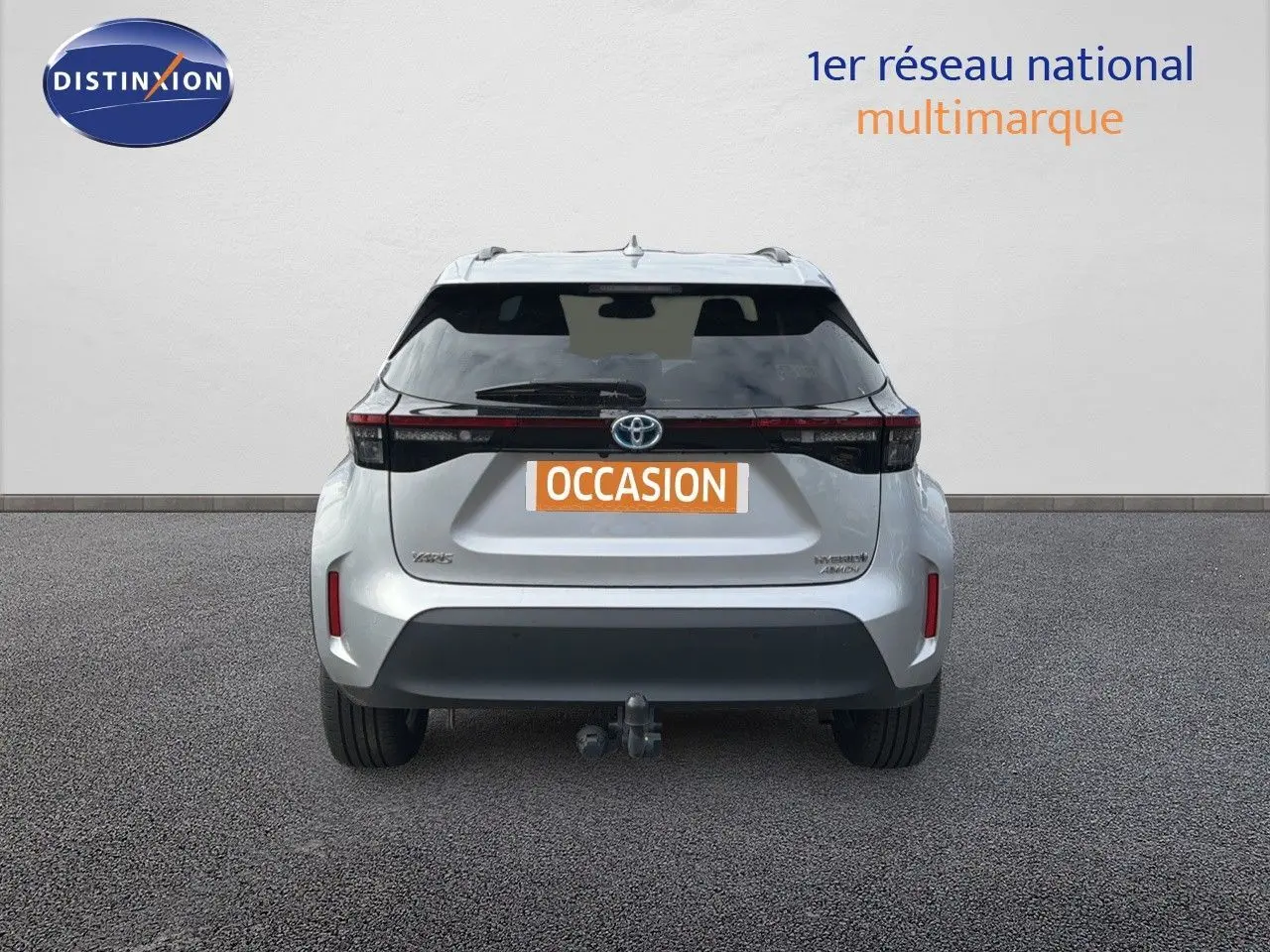 Vue arrière d'une Toyota Yaris Cross gris minéral 2023 avec attelage et feux LED distinctifs.