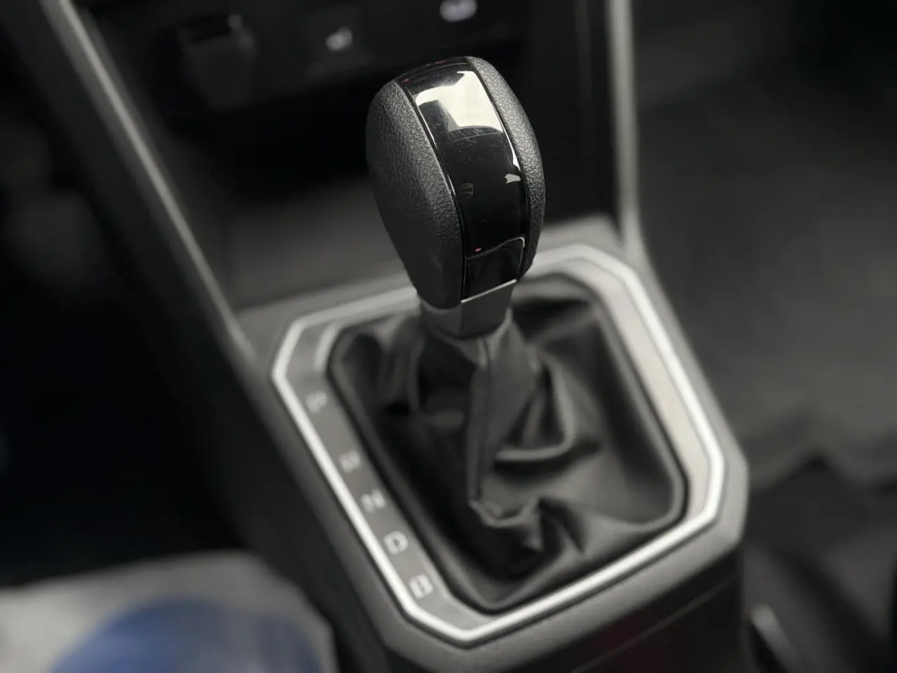 Gros plan sur le levier de vitesses automatique noir du DACIA JOGGER 1.6 Hybrid 140 Extreme 7PL, intérieur sobre.