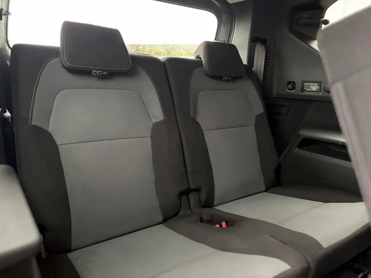 Vue intérieure du troisième rang de sièges gris et noir du Dacia Jogger 1.6 Hybrid 140 Extreme 7 places, avec appuie-têtes intégrés.