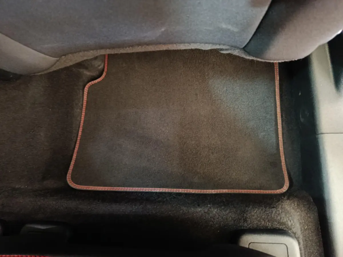 Tapis de sol noir avec surpiqûres rouges dans l'habitacle d'un Ford Kuga 2.0 EcoBlue 2024.