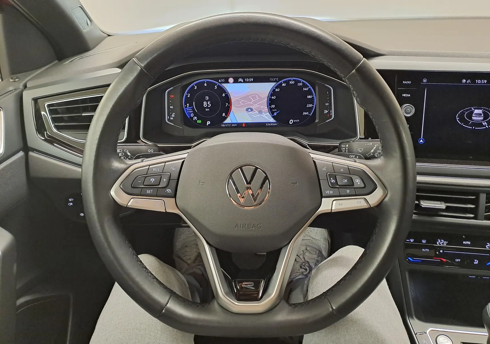 Vue centrée sur le volant cuir noir du Volkswagen Taigo 1.5 TSI R-Line avec tableau de bord digital et écran tactile.