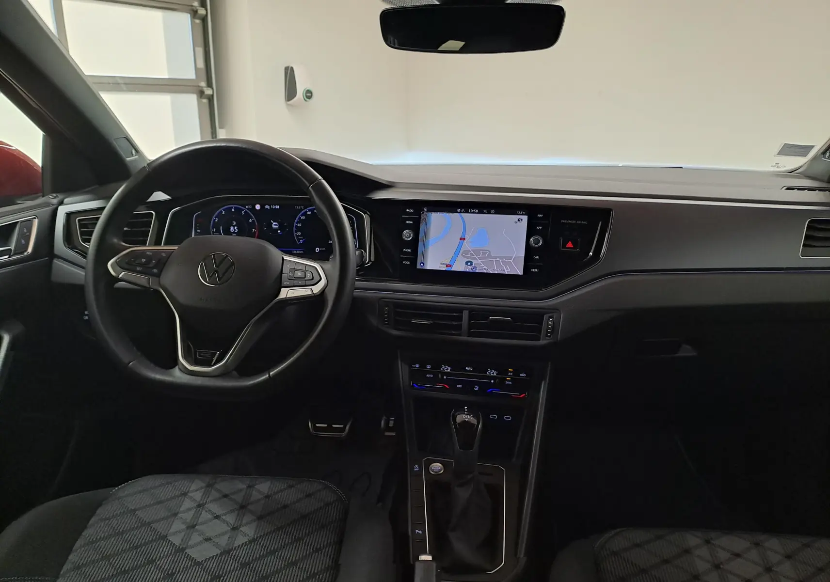 Vue intérieure avant du Volkswagen Taigo 1.5 TSI R-Line 2021, tableau de bord noir avec écran tactile et volant multifonction.