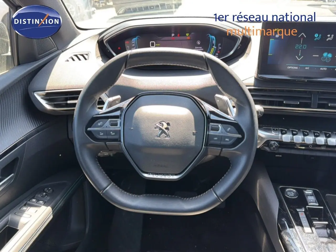 Vue intérieure centrée sur le volant cuir noir du Peugeot 3008 Hybrid 2024 avec tableau de bord numérique et écran tactile.