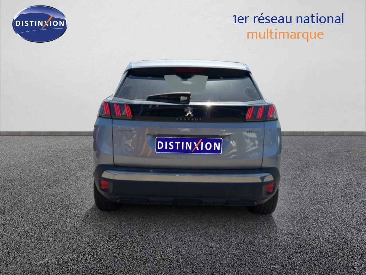 Vue arrière d’un Peugeot 3008 Hybrid gris Artense métal 2024, avec feux arrière à triple griffes rouges et logo central.