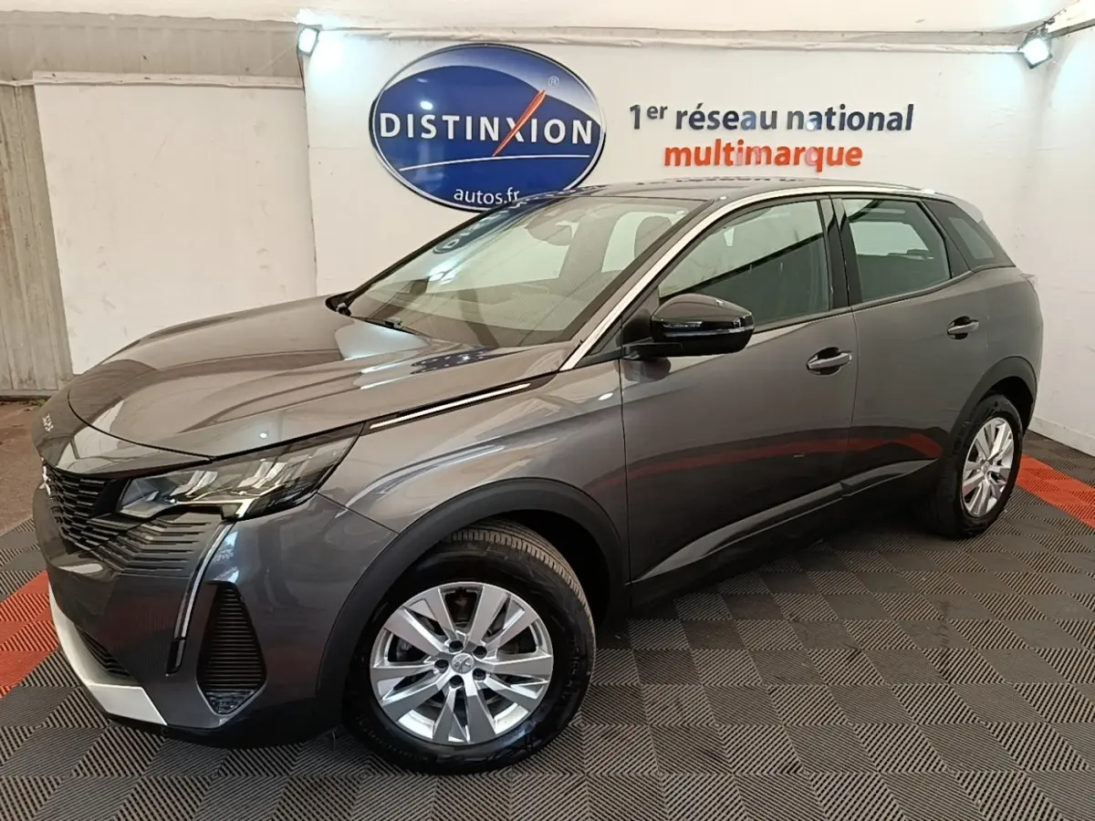 Peugeot 3008 gris foncé vue 3/4 avant droit en intérieur, avec jantes alliage et calandre distinctive.